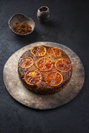 Traditional American upside-down bloody orange cake offered as closeup on a modern design tray with copy space の写真素材