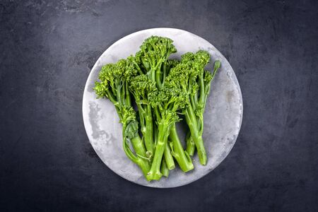 Fresh rapini broccoli rabe as top view on a gray plate with copy space の写真素材