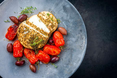 Modern style traditional Italian Ricotta al forno cake with barbecue tomatoes and Kalamata olives offered as top view on a design plate with copy space rightの写真素材