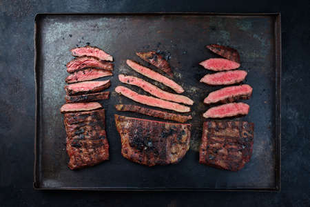 Traditional barbecue wagyu gourmet beef steaks served as top view on a rustic black boardの写真素材
