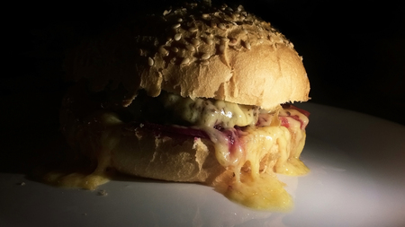 Appetizing hot burger on a white background with a dark background.の写真素材