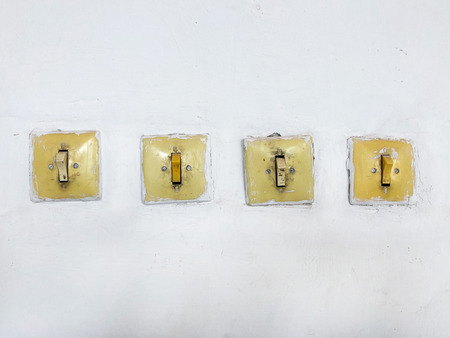 Vintage switches and light switches on the wall. Four subjects electricians in the room.の写真素材