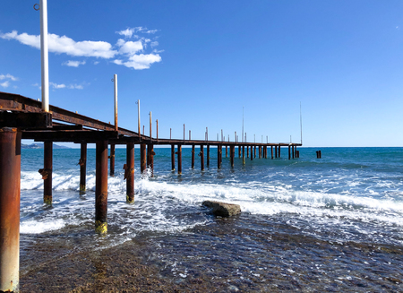 Rusty metal pier extending into the Mediterranean waters. Seascape on a sunny calm day.の写真素材