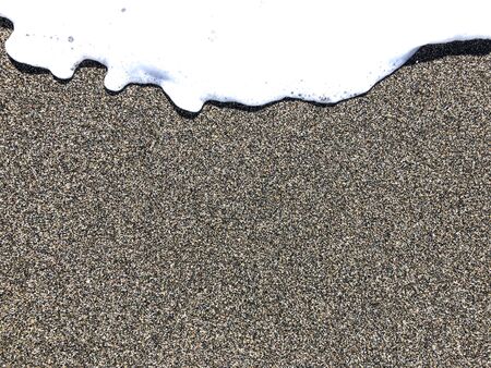 A soft foamy wave gradually covers the clear seashore. Background with the ability to use text.の写真素材