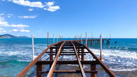 Rusty metal pier extending into the Mediterranean waters. Seascape on a sunny calm day.の写真素材