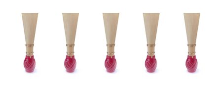 Double reed for bassoon with red thread on a wide white background. Five mouthpieces for wind musical instruments. With a slight shadow.の写真素材