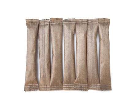 Brown paper sticks for sugar, salt, coffee and spices on a white background with a light shadow. Eco packaging for bulk products.の写真素材