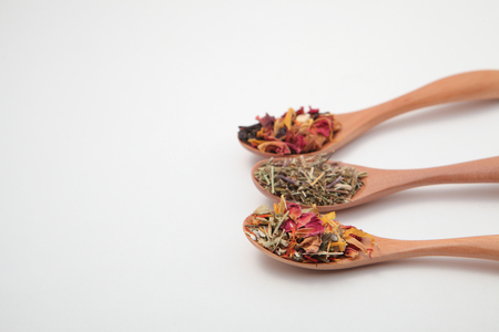 Blend herbal tea leaves in wooden spoons isolated white backgroundの写真素材