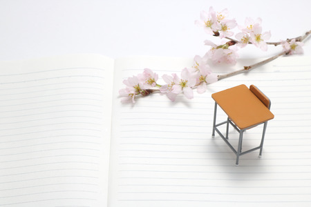 Study desk and cherry blossoms on the notebook.の写真素材