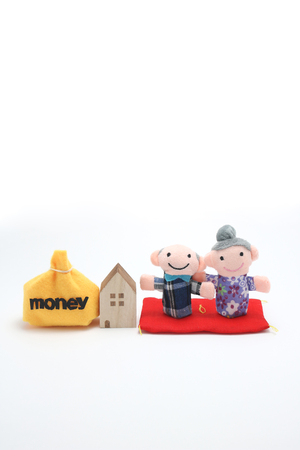 Elderly couple of dolls and the house and the money.の写真素材
