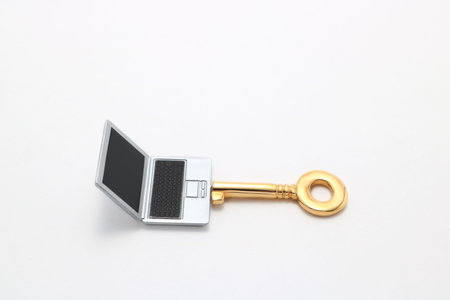 Laptop and key. Miniature notebook PC and key on white background.