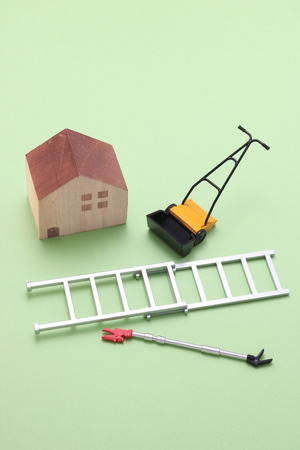House, ladder, high branch pruning shears, and lawn mower.の写真素材