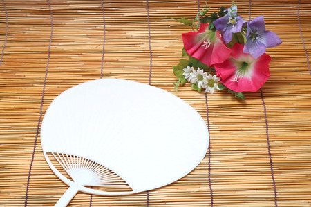 Morning glory and fan on bamboo blind. Japanese summer concept.の写真素材