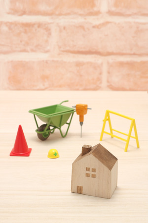 Miniature house and construction tools on wood.の写真素材
