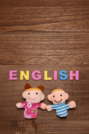 Alphabet letters ENGLISH and children dolls on wood. English education concept.の写真素材