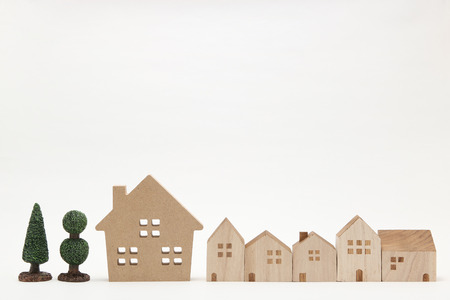 Miniature houses and trees on white background. Building blocks arranged in row.の写真素材