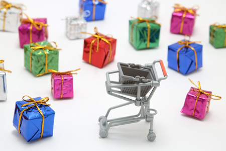 Steel shopping cart and colorful gift boxes on white background. Buying presents concept.の写真素材
