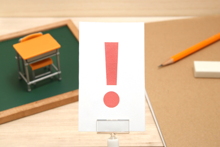 Exclamation mark on white paper with the study tool as the background. Concept of learning inspiration.の写真素材