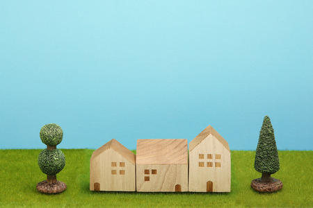 Houses on green grass over blue sky. Mortgage concept.の写真素材