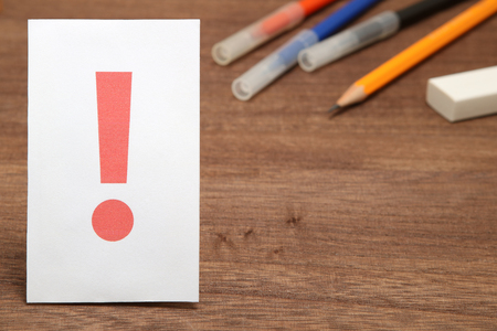 Exclamation mark on white paper, and stationery as the background. Concept of learning inspiration.の写真素材