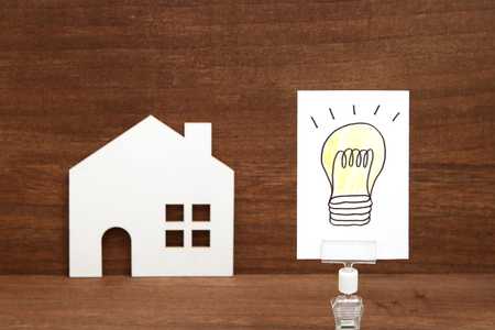 Handwritten bulb illustration and house on wood. Eco technology and energy concept.の写真素材
