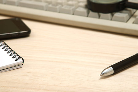 Business concept.  Memo pad, smart phone, and magnifying glass with computer keyboard. Workplace for...