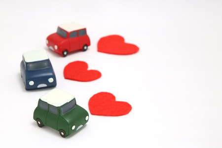 Some red hearts and cars on white background. Safe driving concept.の写真素材