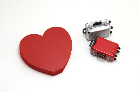 Miniature two suitcases and a red heart on white background. Concept of honeymoon.の写真素材