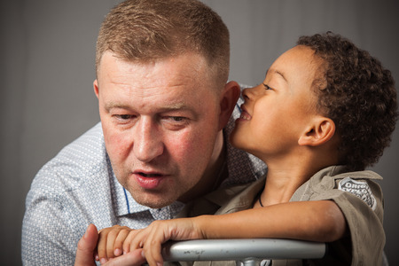 portrait of a black boy with different emotions with his interracial fatherの写真素材