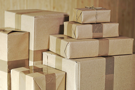 A stack of large and small postal parcels on the tableの写真素材