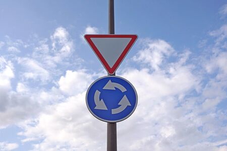 Traffic signs on blue sky background. Circular motion road sign and give way signの写真素材