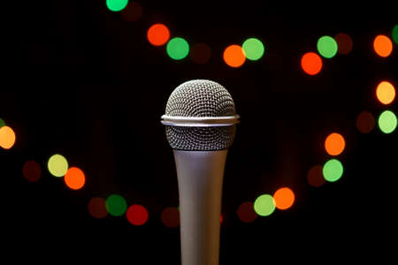 Microphone on stage against the background of multi-colored lightsの写真素材