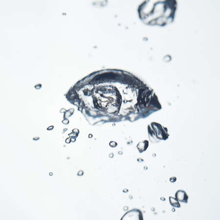 Abstract air bubbles in clear water on a white backgroundの写真素材