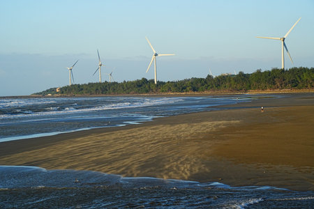 Wind turbines on the beach at low tide.の写真素材