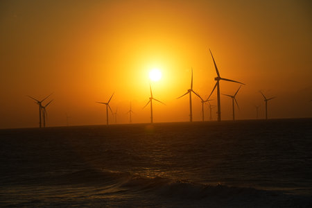 Wind turbines at sunset in the sea. Wind turbines for electric power production.の写真素材