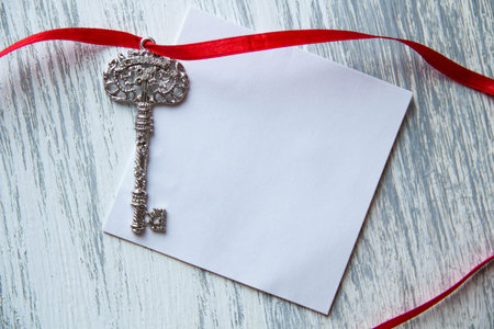 Sticky note and key on wood background