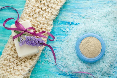 natural organic soap and sea salt herbal bath  on a blue wooden table, with flowersの写真素材