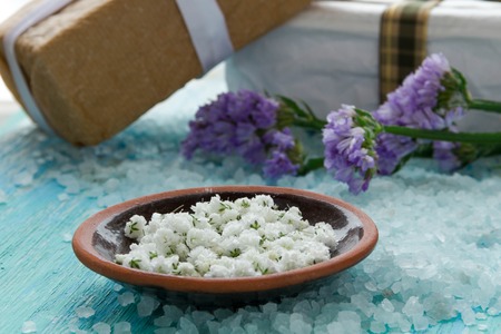 sea salt  on a blue wooden table, Spa with flowersの写真素材