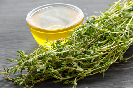 Fresh cumin and oil in a glass bottle  wooden backgroundの写真素材