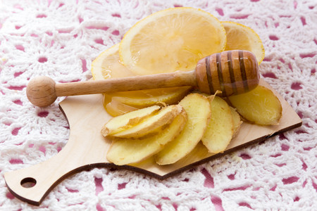 Cold care - honey, lemon, ginger, cinnamon sticks on pink backgroundの写真素材