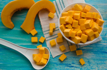 fresh pumpkin cut into pieces on wooden background, food, recipesの写真素材