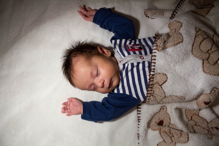 Sleeping at night the newborn boy lay in the crib. Top viewの写真素材