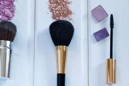 women's accessories cosmetics. Makeup brushes and crushed eyeshadow on woodenの写真素材