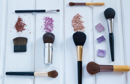 women's accessories cosmetics. Makeup brushes and crushed eyeshadow on woodenの写真素材