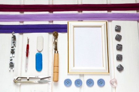 Vintage background with sewing accessories, tools, sewing kit. Scissors, bobbins with thread and needles on wooden white backgroundの写真素材