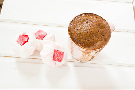 offee morning concept. Sweet pastel colored marshmallow and cup of coffee on aquamarine backgroundの写真素材