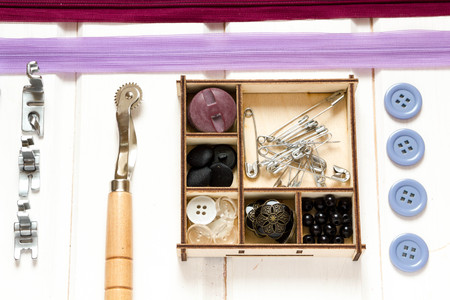 Vintage background with sewing accessories, tools, sewing kit. Scissors, bobbins with thread and needles on wooden white backgroundの写真素材