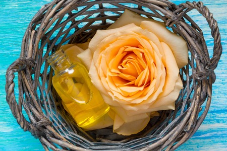 cosmetic products from rose essential oil, flowers on turquoise wooden backgroundの写真素材