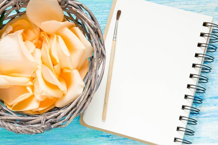 flowers rose petals on turquoise wooden background, notebook, mockup, place for text,の写真素材