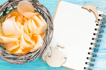 flowers rose petals on turquoise wooden background, notebook, mockup, place for text,の写真素材